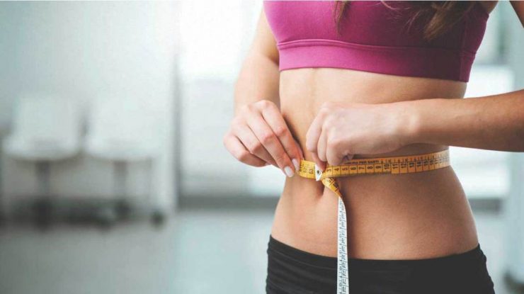 woman measuring stomach 1296x728